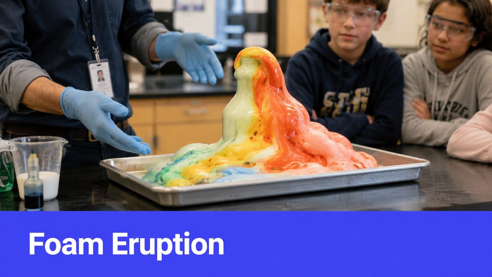 A science teacher demonstrating a colorful foam eruption experiment to students wearing safety goggles in a classroom.