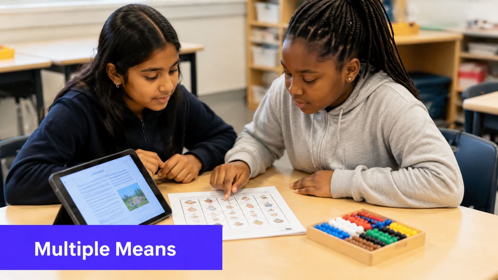 Two students sit at a wooden desk collaborating on an educational activity using a tablet and worksheet.